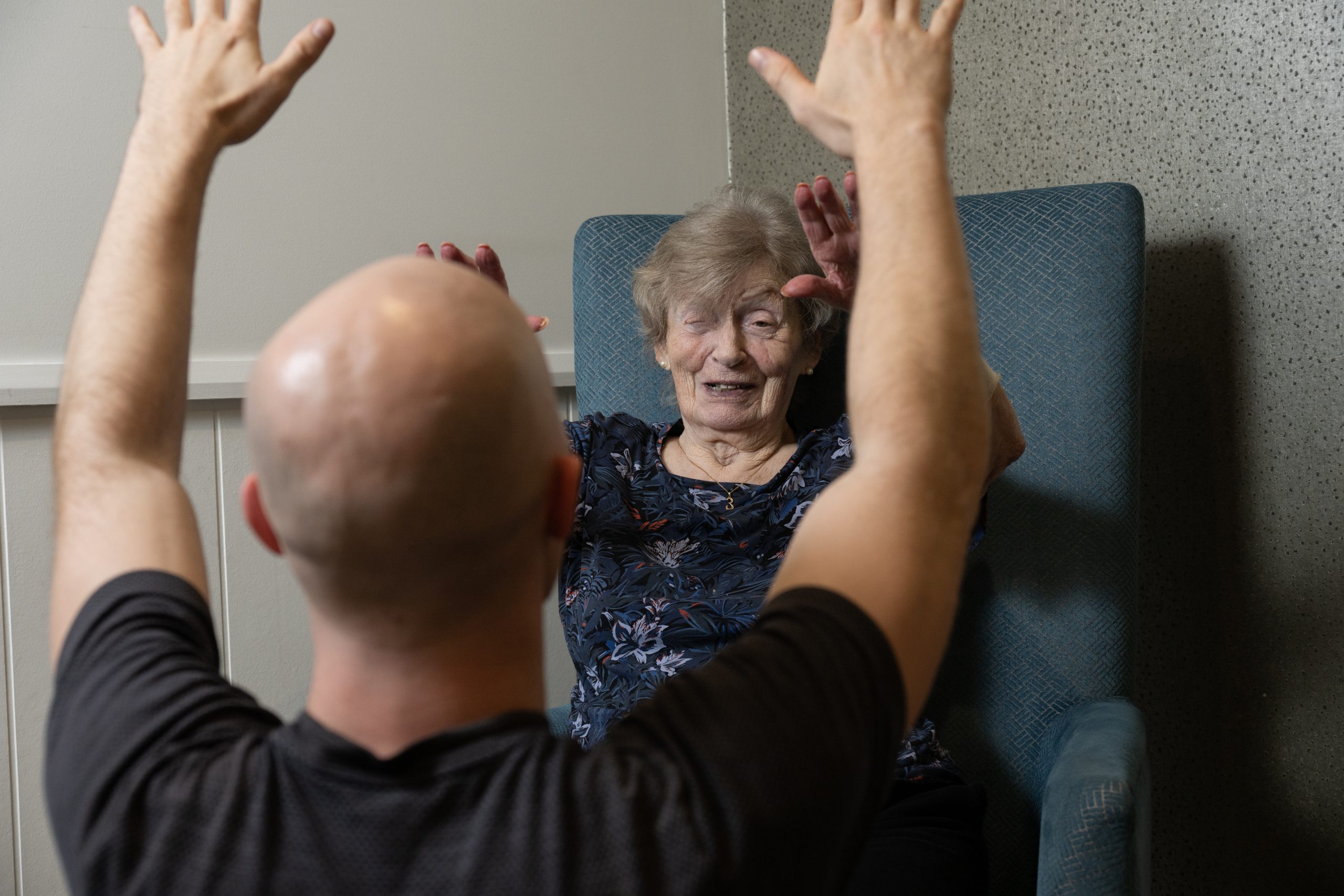 GM Physiotherapy physiotherapist doing seated arm exercises with an older client at home in Hollywell